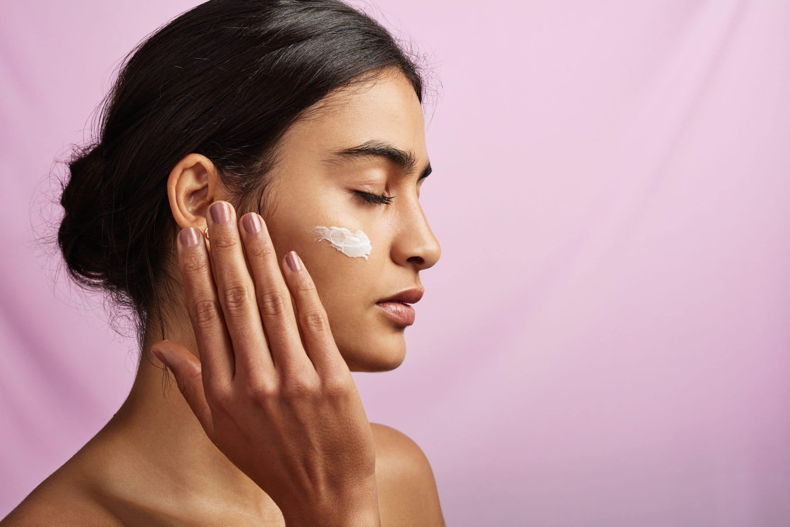 A Woman Applies Ultimate Skincare Products For A Glowing Complexion