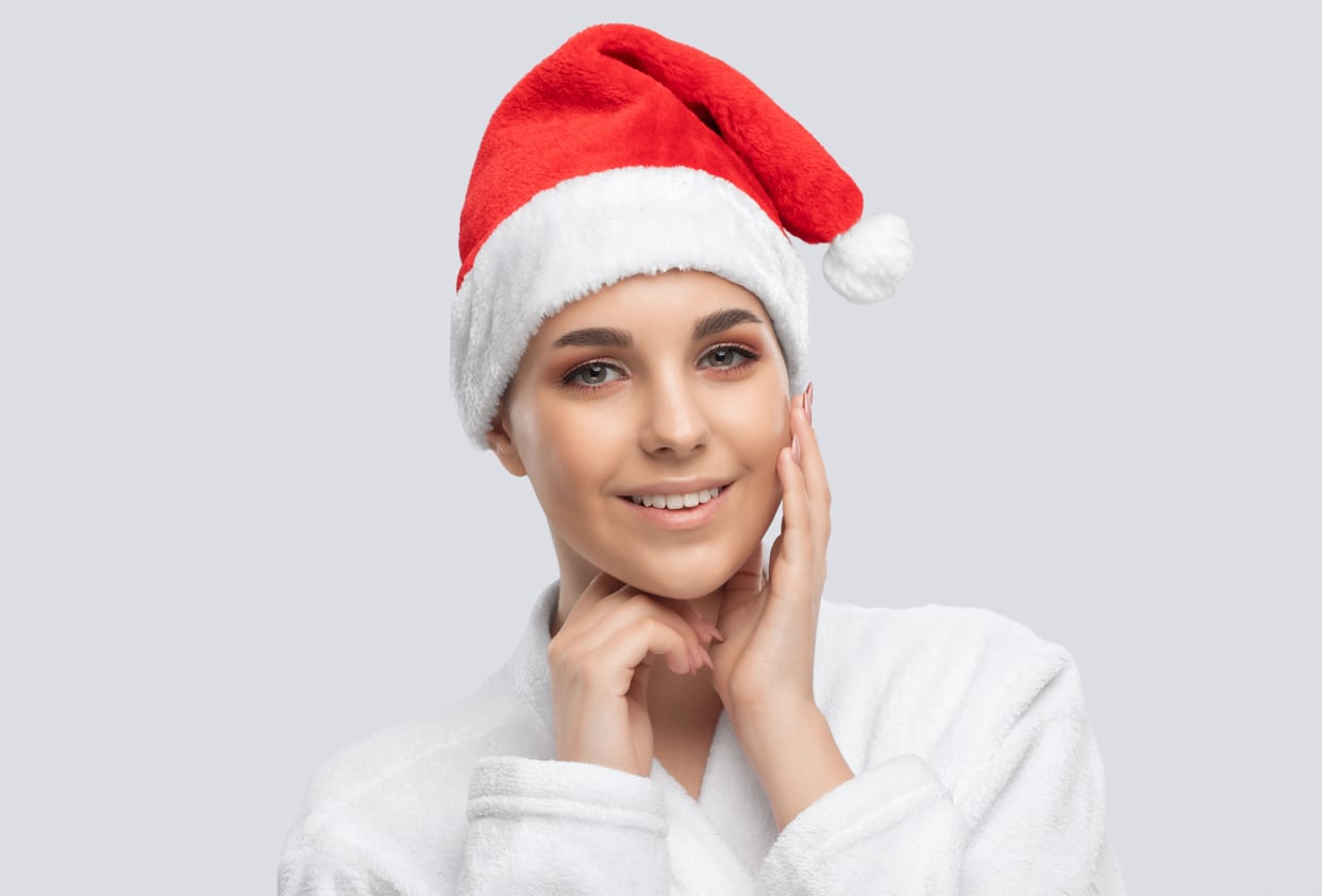 A Beautiful Woman In A Santa Hat Represents Giving The Gift Of Confidence With Cosmetic Procedures